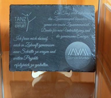Eine gravierte Tafel mit der Aufschrift "Tanzgruppe" und einem Logo.